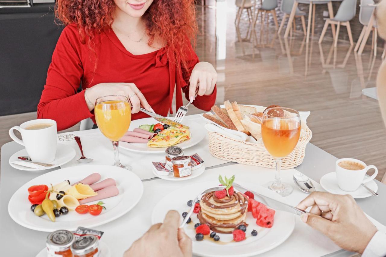 The Bentley Luxury Hotel & Suites Doha Exterior foto A woman eating breakfast