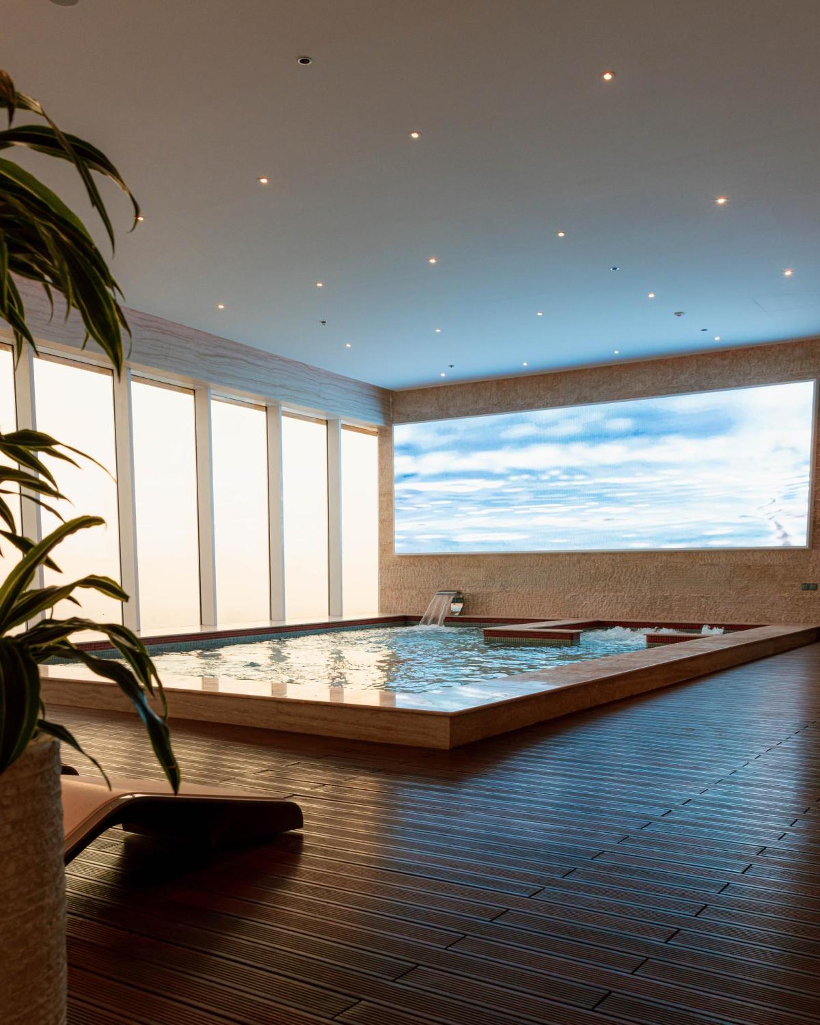 The Bentley Luxury Hotel & Suites Doha Exterior foto A swimming pool with a translucent ceiling